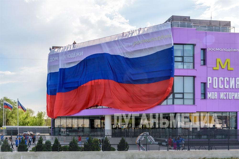В луганском Доме молодежи в честь Дня Российской Федерации «Молодая Гвардия Единой России» (МГЕР) ЛНР и «Волонтерская рота боевого братства» развернули большой российский флаг, поздравляя жителей города с этим великим праздником