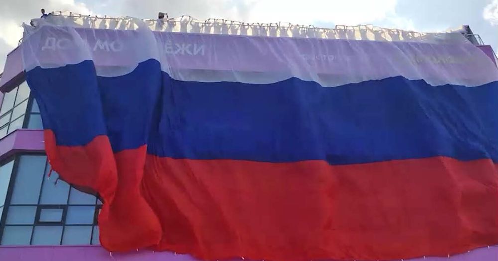 Активисты растянули гигантский флаг РФ на Доме Молодежи в Луганске