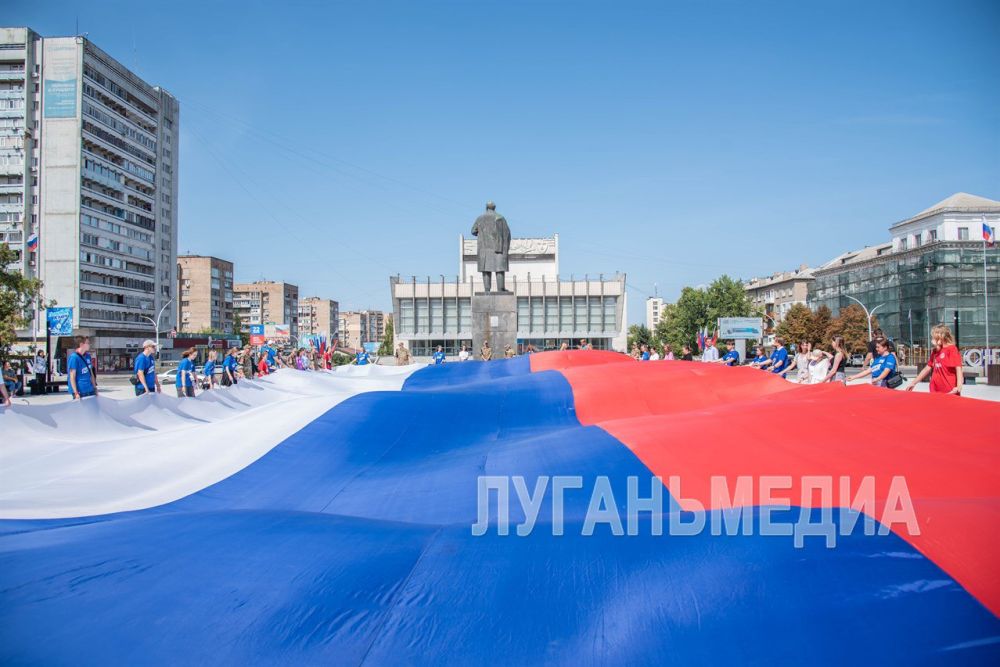 Активисты Молодой Гвардии Единой России и молодежь Луганска развернули в центре города 30-метровый флаг России
