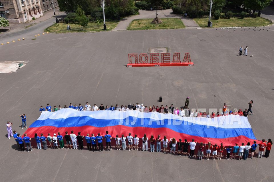 В Алчевске на проспекте Ленина развернули самый большой российский флаг – длиной 22 метра