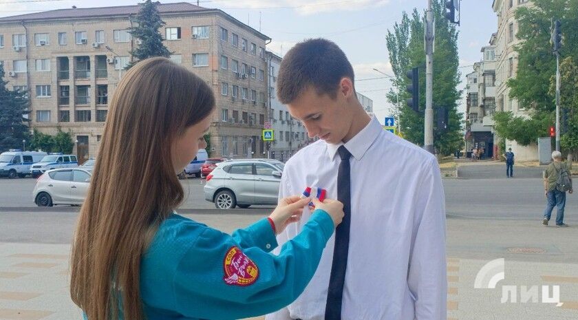 Активисты в канун Дня России раздали ленты в виде триколора жителям Луганска