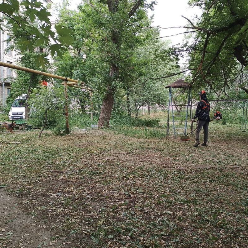 Работники Луганского филиала управляющей компания продолжают планомерно косить траву и распиливать ветки